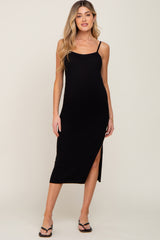 woman wearing a black ribbed maternity dress with spaghetti straps and a side slit
