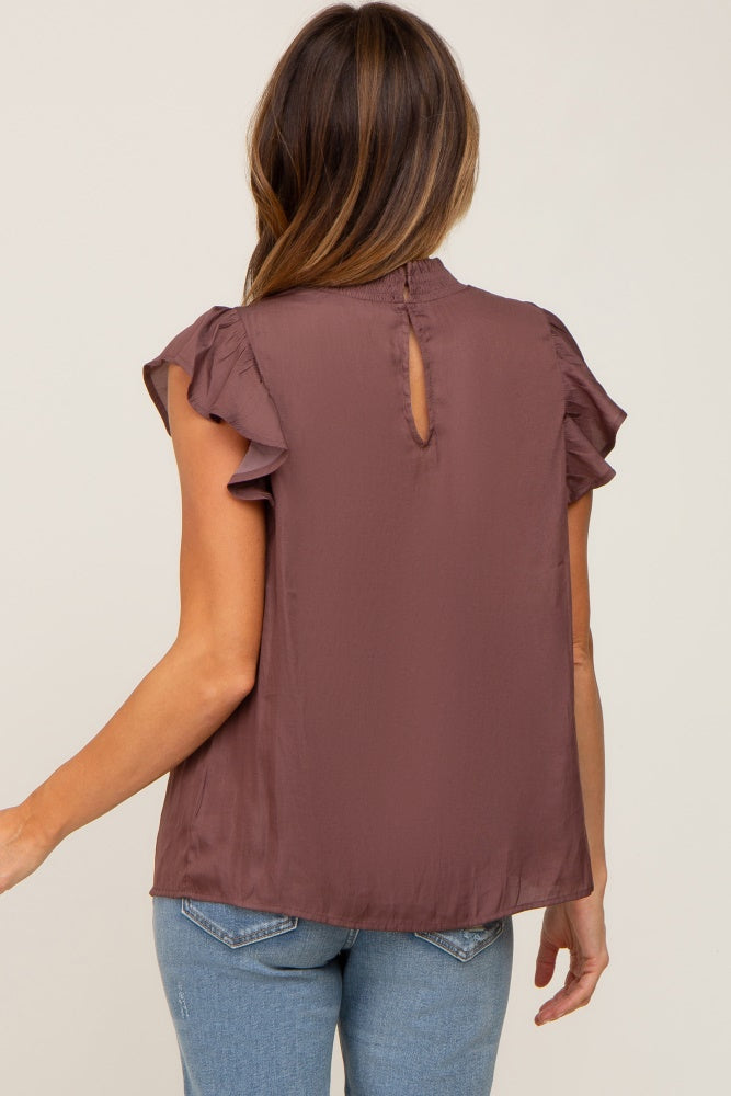 Back view of a woman wearing a mauve ruffle sleeve blouse with a high neck and keyhole detail
