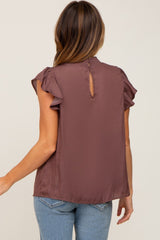 Back view of a woman wearing a mauve ruffle sleeve blouse with a high neck and keyhole detail