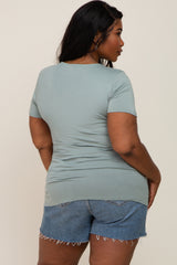 back view of a woman wearing a sage green short sleeve t-shirt and denim shorts