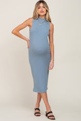 woman wearing a fitted light blue ribbed maternity dress and showing her baby bump