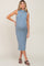 woman wearing a fitted light blue ribbed maternity dress and showing her baby bump