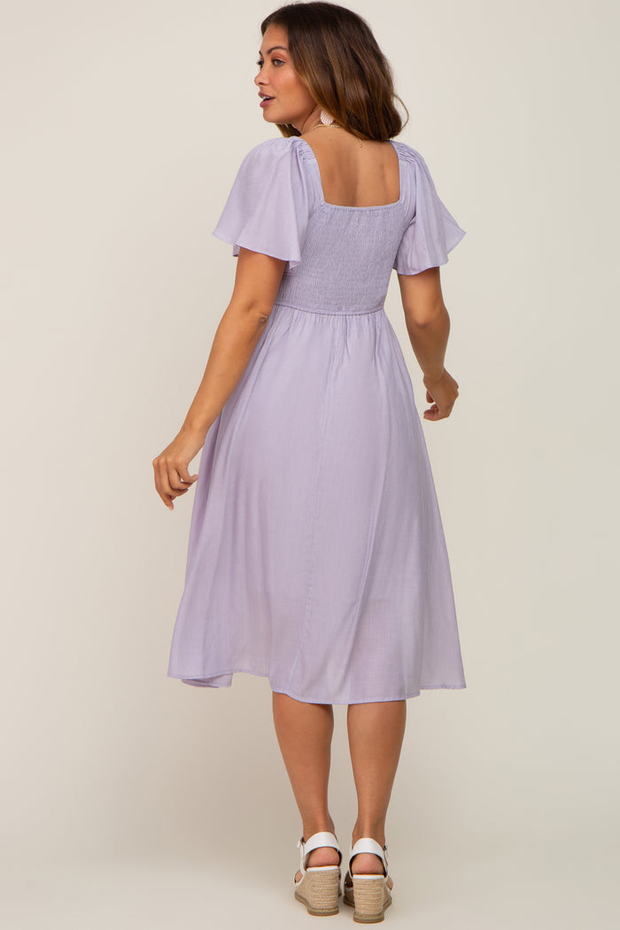 woman wearing a light lavender maternity dress with flutter sleeves and a square back design