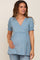 woman wearing a light blue maternity top with a v-neck and puff sleeves, highlighting her baby bump