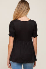 woman wearing a black maternity top with short puff sleeves and a flowy silhouette