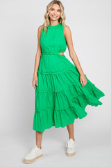woman wearing a bright green sleeveless tiered midi dress with side cutouts and white platform sneakers