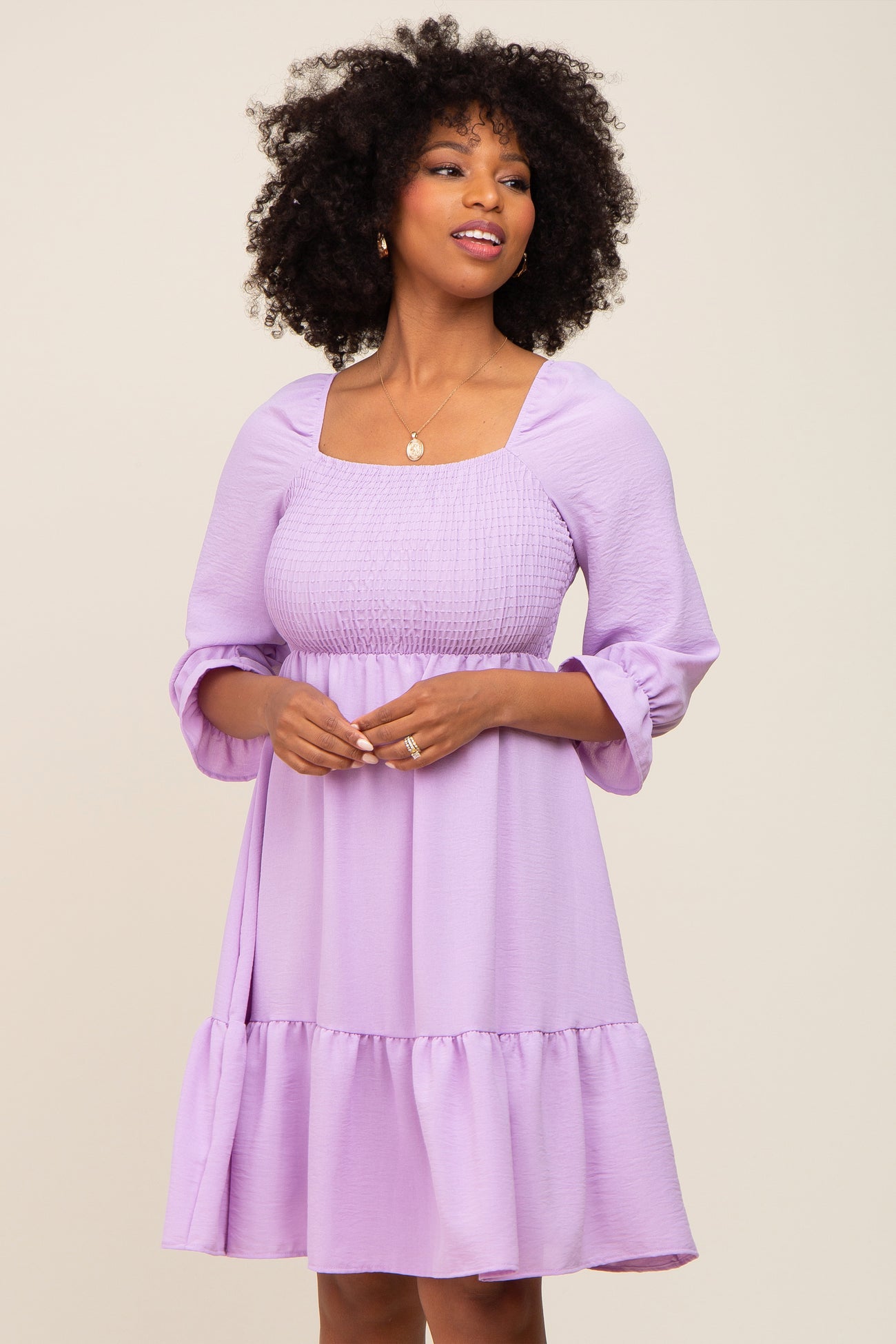 woman wearing a lavender square neck dress with smocked bodice and balloon sleeves, featuring a flared skirt