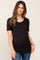 woman wearing a black short sleeve maternity top that accentuates her baby bump