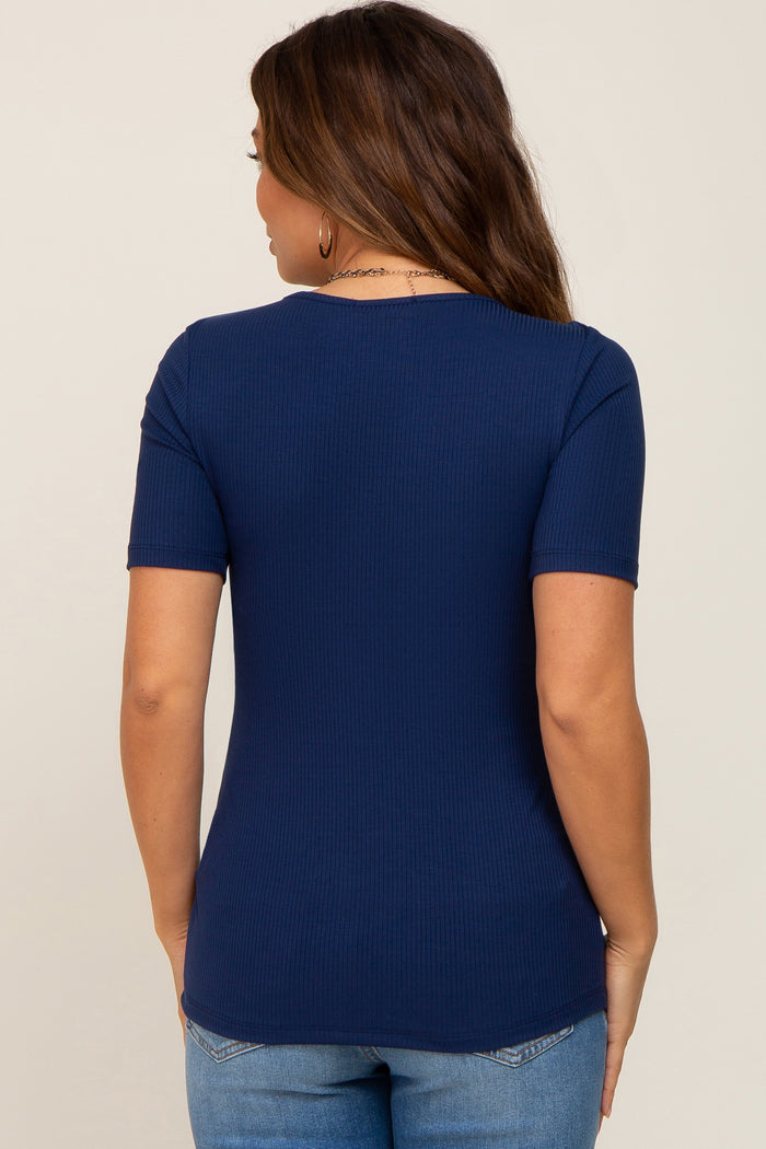 woman wearing a navy blue short sleeve maternity top, shown from the back, paired with light blue jeans