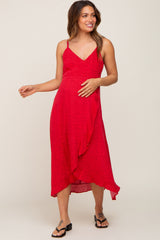 woman wearing a red maternity dress with adjustable straps and asymmetrical hem, showcasing her baby bump