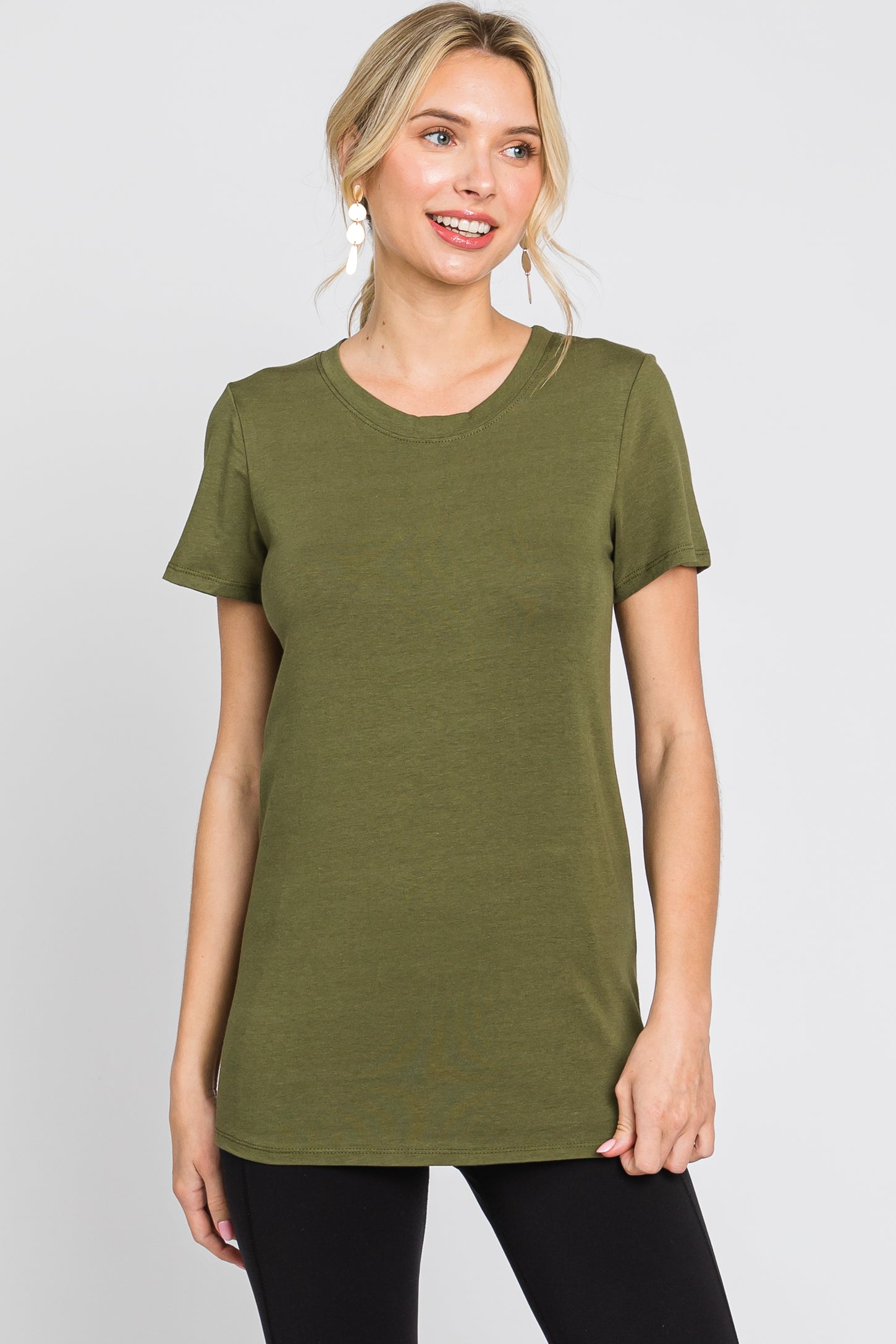 woman wearing an olive green short sleeve crew neck t-shirt and black pants