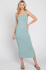 woman wearing a light teal ribbed maxi dress with a side slit and spaghetti straps