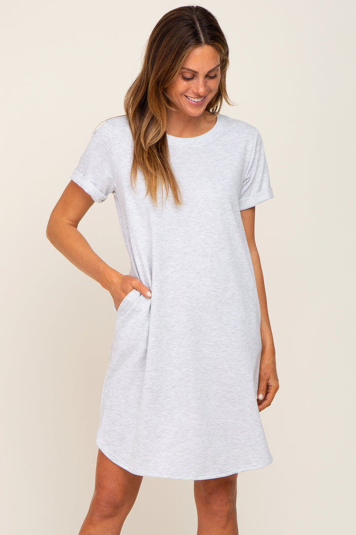 woman wearing a light gray short sleeve t-shirt dress with pockets and a relaxed fit