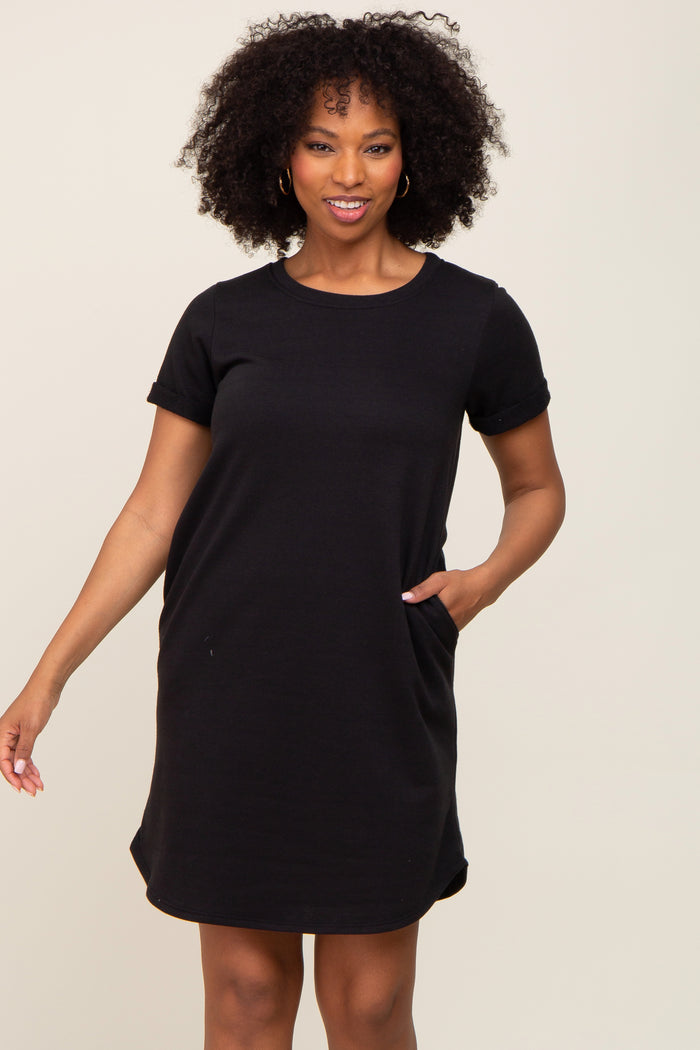 woman wearing a black short sleeve casual dress with pockets and a relaxed fit