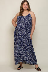 woman wearing a navy blue maternity plus maxi dress with a leaf print and adjustable straps