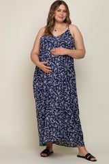 woman wearing a navy blue floral print maternity maxi dress with adjustable straps and a visible baby bump