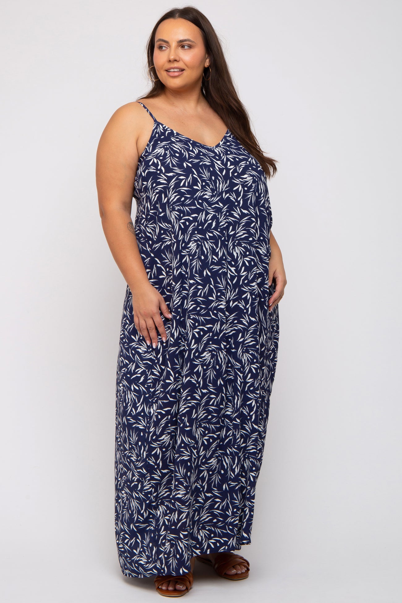 woman wearing a navy blue leaf print maxi dress with spaghetti straps