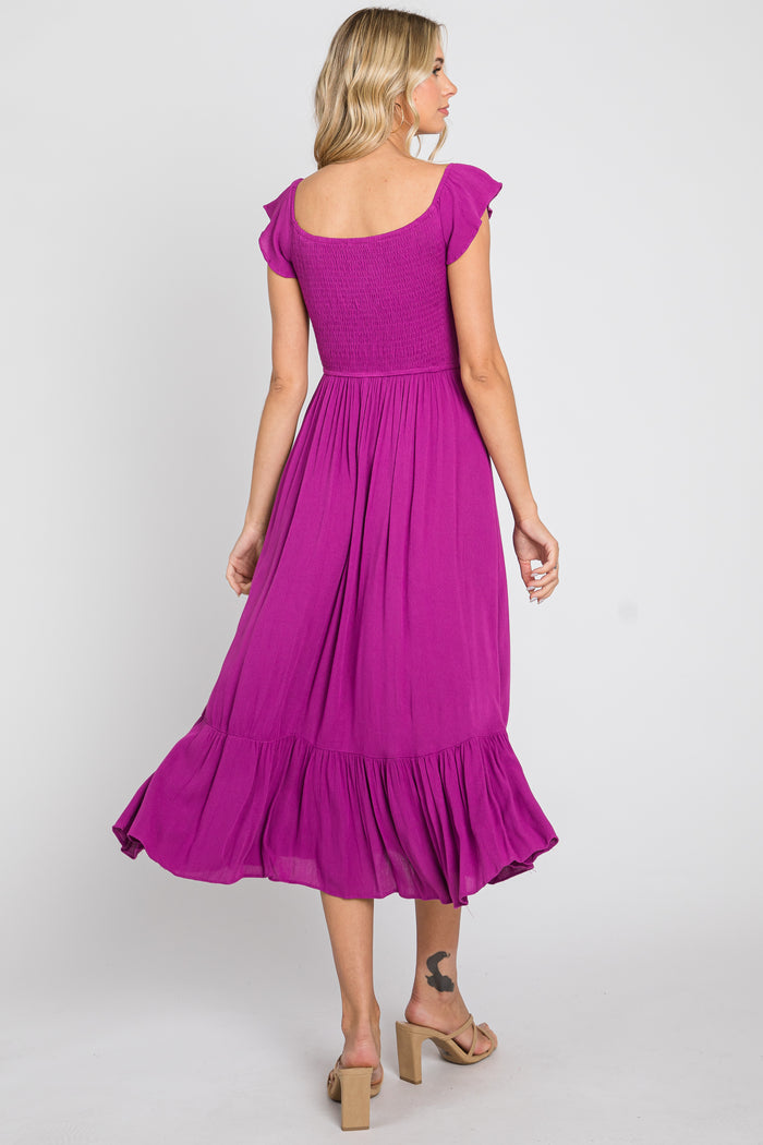 Woman from behind wearing a purple smocked midi dress with ruffle sleeves and a tiered skirt