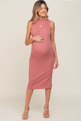 woman wearing a dusty rose sleeveless maternity dress with a fitted silhouette and a visible baby bump