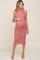 woman wearing a dusty rose sleeveless maternity dress with a fitted silhouette and a visible baby bump