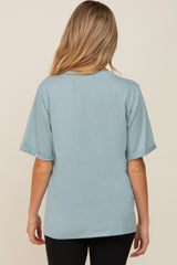 woman wearing a soft blue short sleeve maternity top, shown from the back