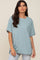 woman wearing a light blue oversized t-shirt with a chest pocket and relaxed fit