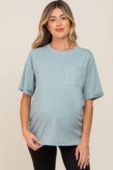 woman wearing a light blue maternity t-shirt with a pocket and rolled sleeves, showing her baby bump