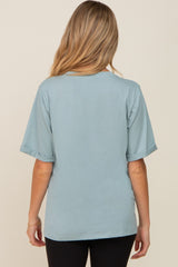 woman wearing a soft blue short sleeve maternity top, shown from the back