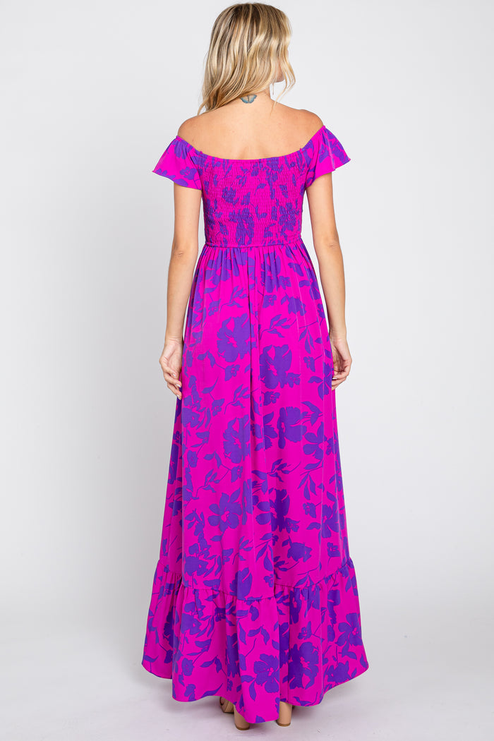 woman wearing a vibrant pink off-the-shoulder maxi dress with floral pattern and smocked bodice, showing the back view