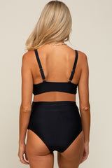 woman wearing a black maternity bikini with a high-waisted bottom and adjustable straps