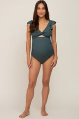 woman wearing a dark green maternity swimsuit with ruffle sleeves and a crossover front design, showcasing her baby bump