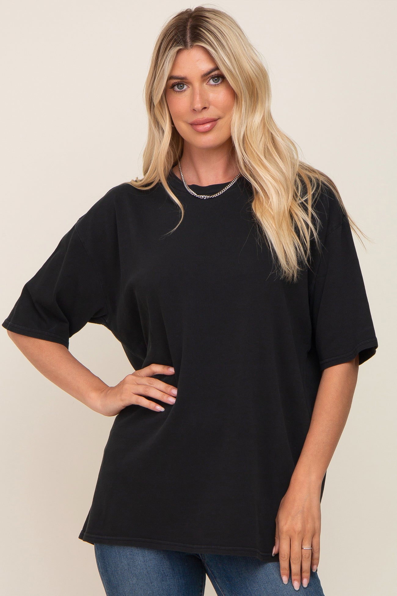woman with blonde hair wearing a black oversized t-shirt and silver chain necklace