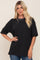 woman with blonde hair wearing a black oversized t-shirt and silver chain necklace