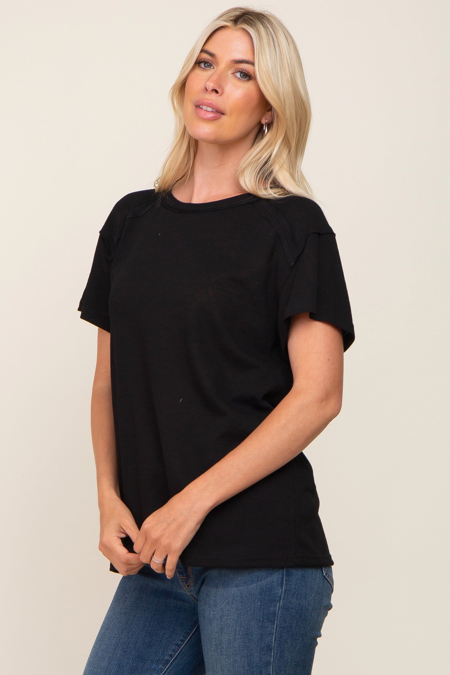 woman wearing a black short sleeve t-shirt with a relaxed fit and blue jeans