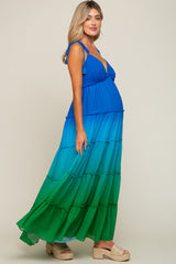pregnant woman wearing a blue and green ombre tiered maternity maxi dress with tie straps and platform sandals