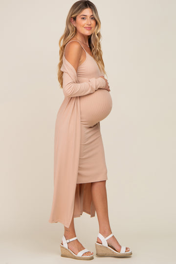 woman wearing a beige ribbed maternity dress with a matching long cardigan and showing her baby bump