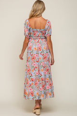 woman wearing a floral maternity maxi dress with puff sleeves and a smocked bodice, showing a comfortable fit for a baby bump