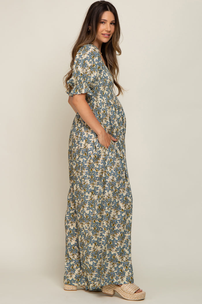 woman wearing a floral print maternity maxi dress with short sleeves and pockets, showing her baby bump