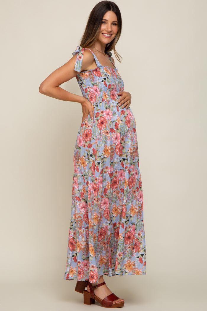 woman wearing a floral maxi maternity dress with adjustable tie straps and a visible baby bump