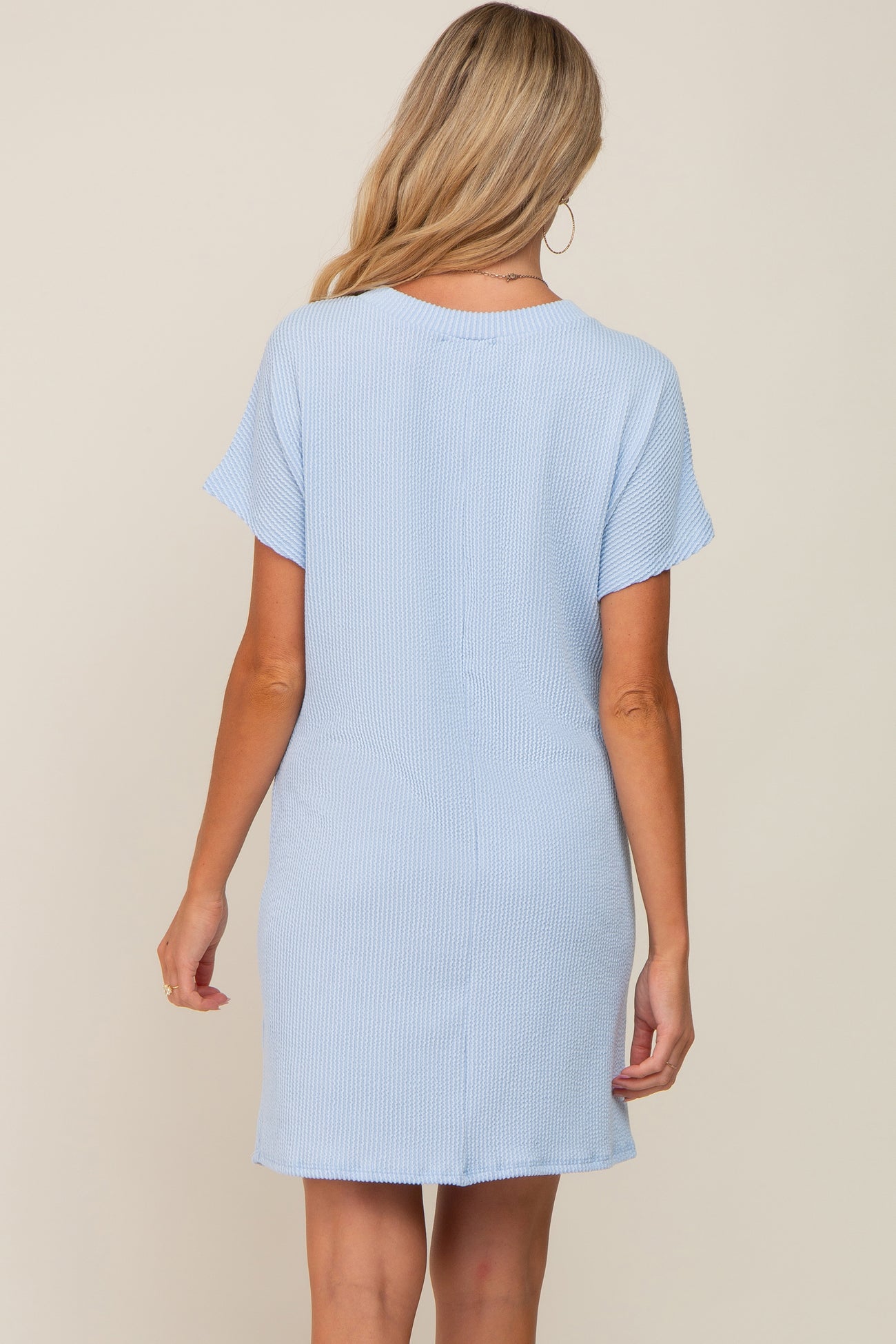woman wearing a light blue maternity dress with short sleeves, shown from the back