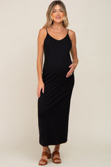 woman wearing a black maternity maxi dress with thin straps and a visible baby bump