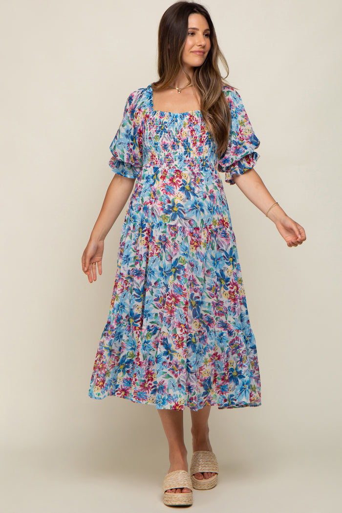 woman wearing a floral patterned maternity dress with puffed sleeves and a square neckline