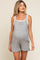 woman wearing a grey maternity romper with side pockets and a white tank top underneath, showcasing her baby bump