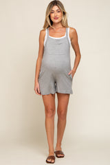 woman wearing a grey maternity short romper with tank top style and pockets, showing her baby bump