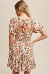 woman wearing a floral print smock dress with puff sleeves and a tie back detail
