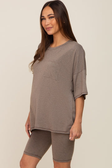 woman wearing a brown oversized maternity top with a pocket and matching bike shorts, displaying a baby bump