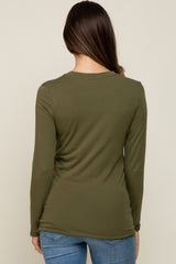 back view of a woman wearing an olive green long sleeve crew neck shirt and blue jeans