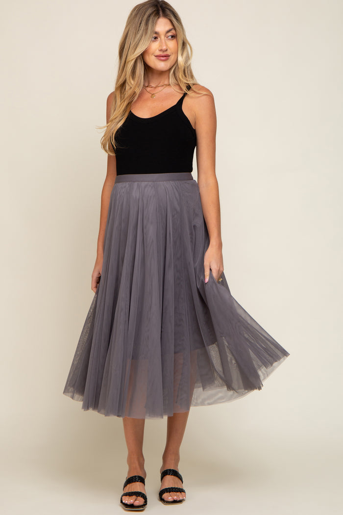 woman wearing a black maternity tank top and a flowy gray tulle midi skirt