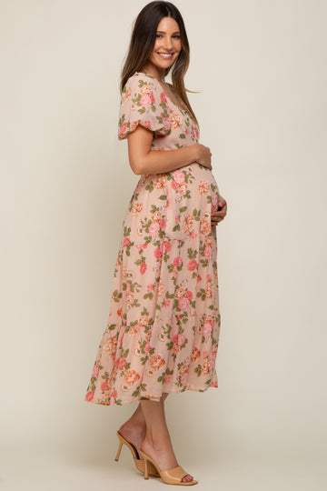 woman wearing a pink floral maternity dress with puff sleeves and a visible baby bump