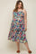 woman wearing a navy blue maternity plus dress with colorful floral print and a fitted bodice, showing her baby bump